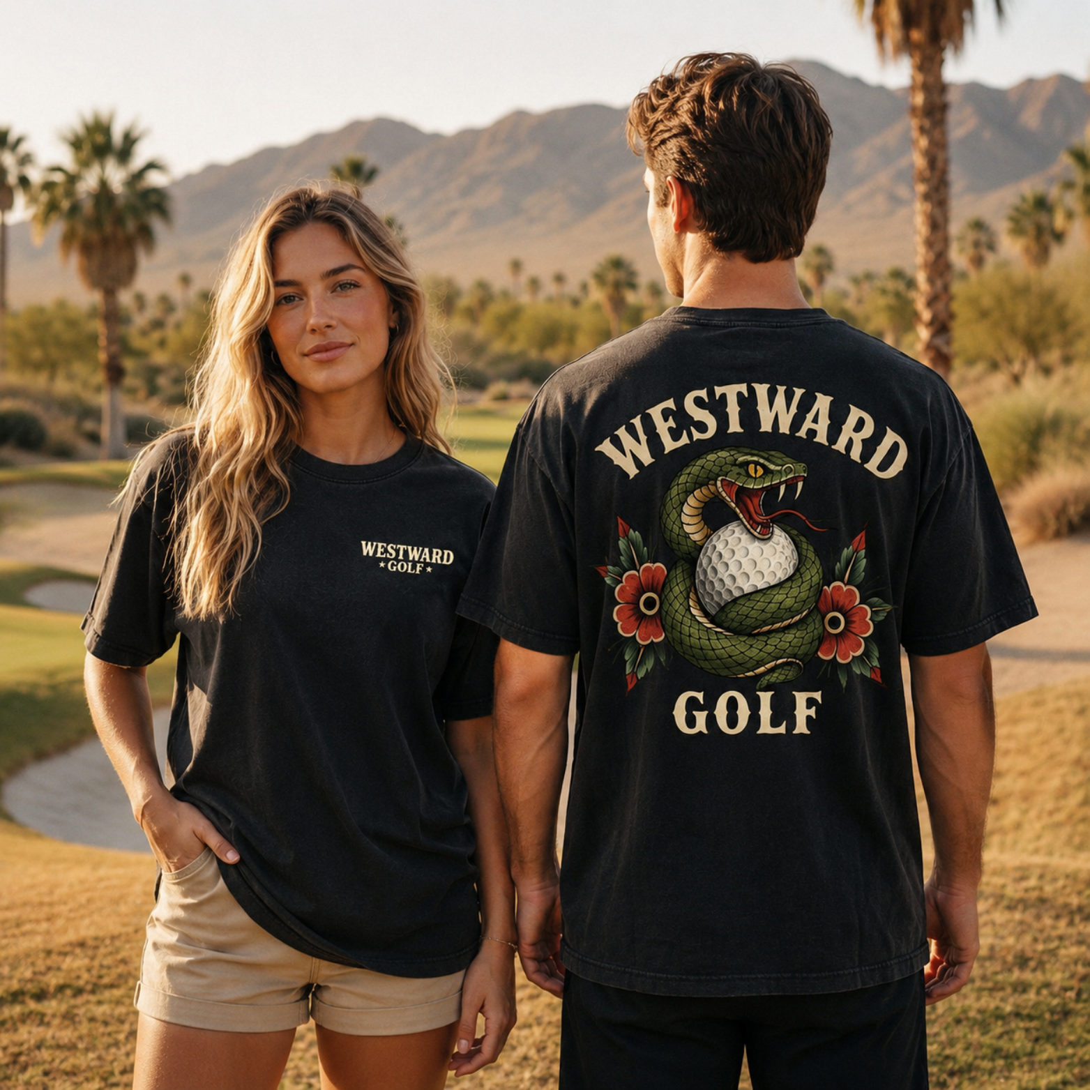 Male and female models wearing black Westward Golf t-shirts on a desert golf course, with the woman facing forward to show the small chest logo and the man facing away to showcase the large snake and golf ball back graphic.