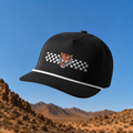 Black cap with tiger logo and checkered pattern against a desert landscape