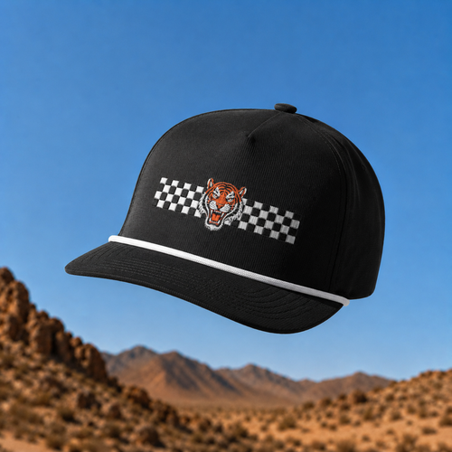 Black cap with tiger logo and checkered pattern against a desert landscape