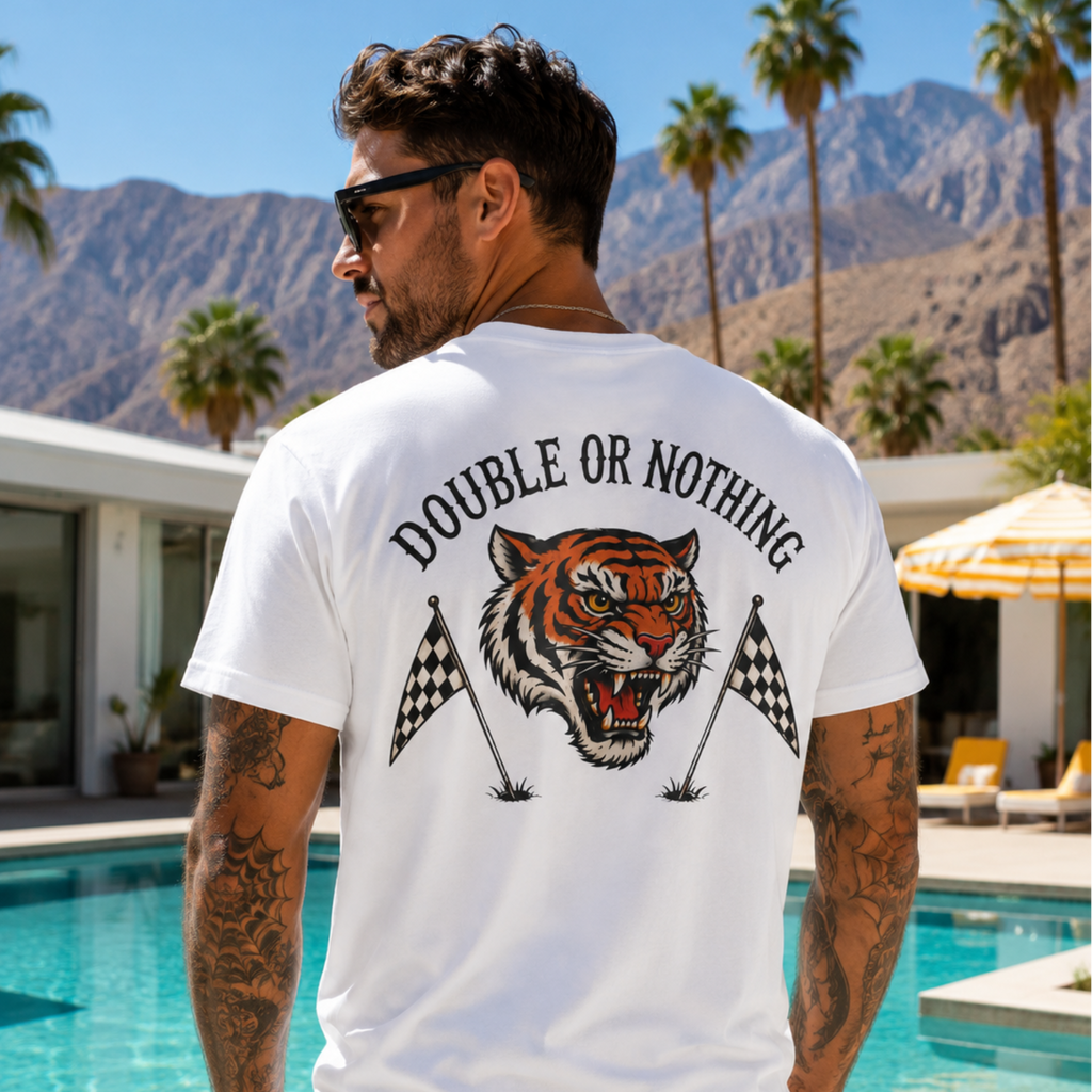 White Double or Nothing golf graphic t-shirt with oversized back print featuring roaring tiger head mascot, crossed checkered golf flags, bold arched lettering, and vintage country club streetwear style.